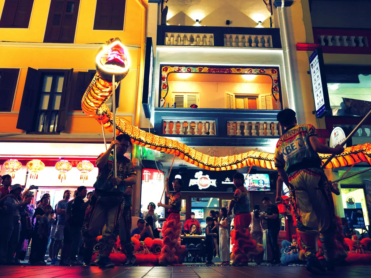 A dragon dance performance on a Chinatown street in Singapore at night